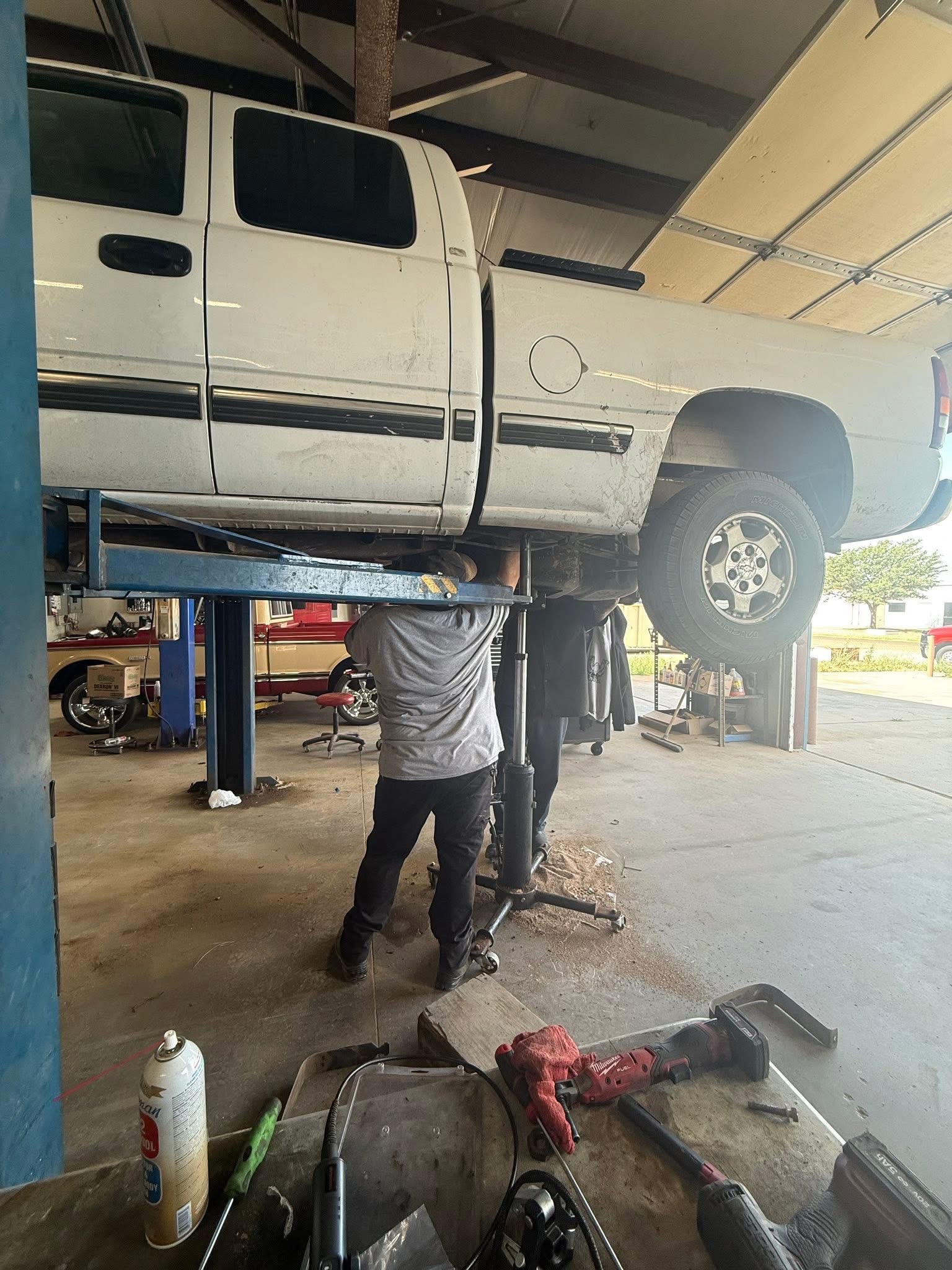 Mechanic working under the hood of a pickup truck
